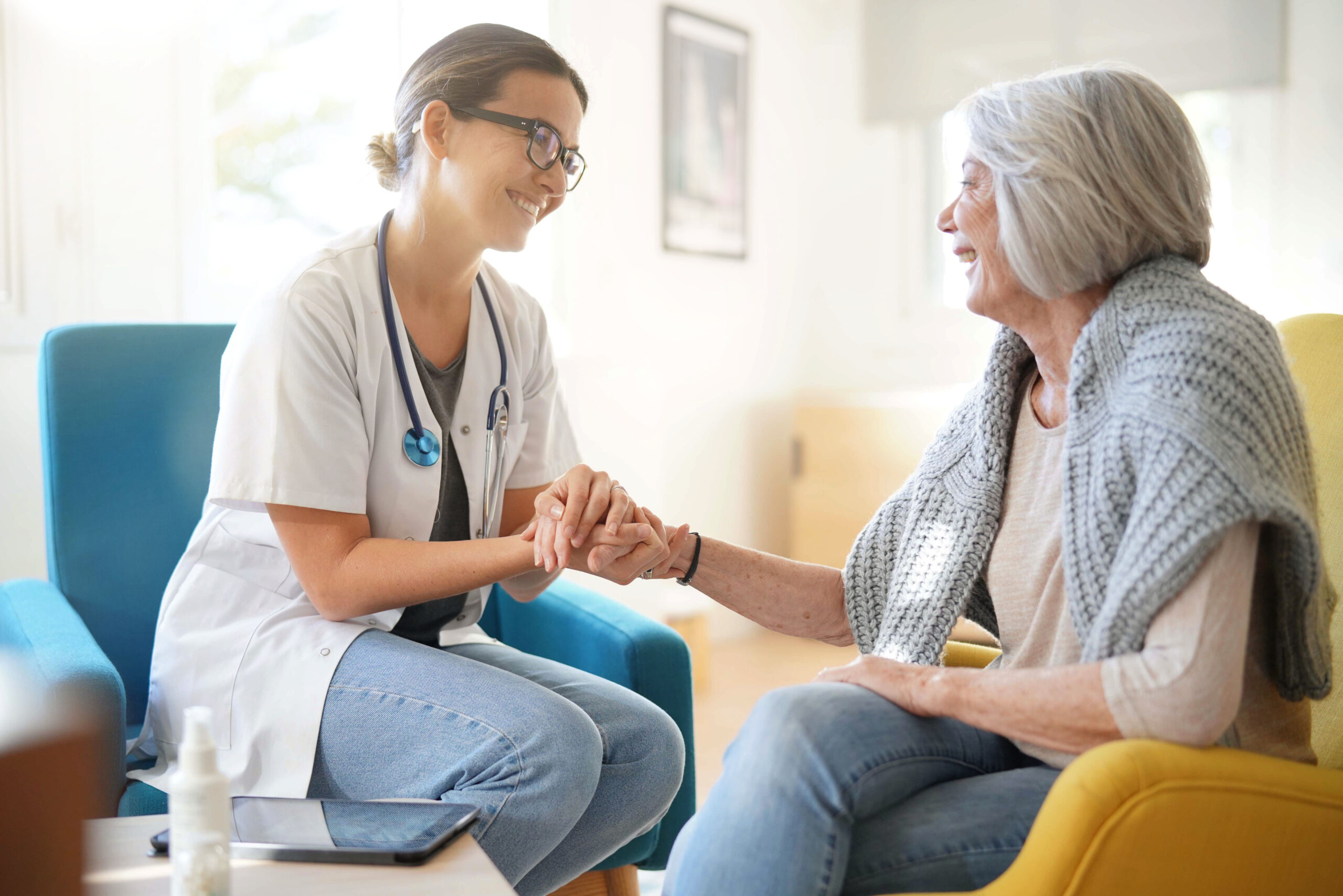 Doctor reassuring older woman in modern clinic