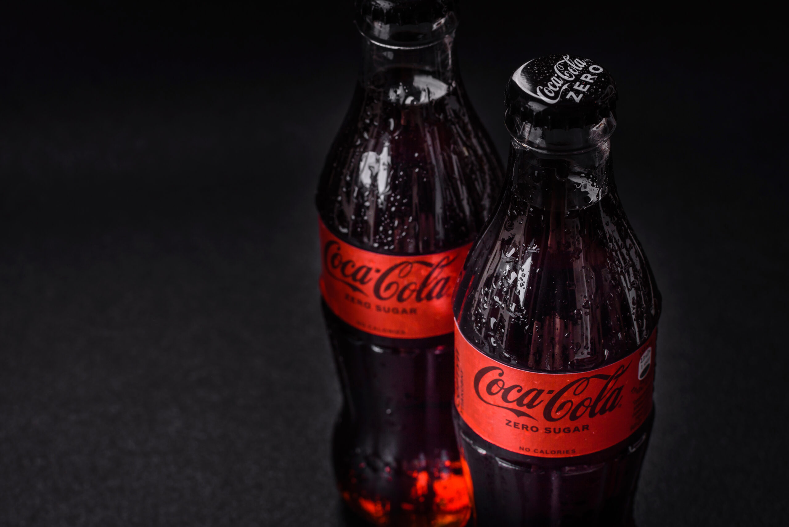 Nikopol, Dnepropetrovsk region/Ukraine - July 15 2024: A bottle of chilled coca-cola zero with drops of water on a black background. Cooling drink on a hot summer day