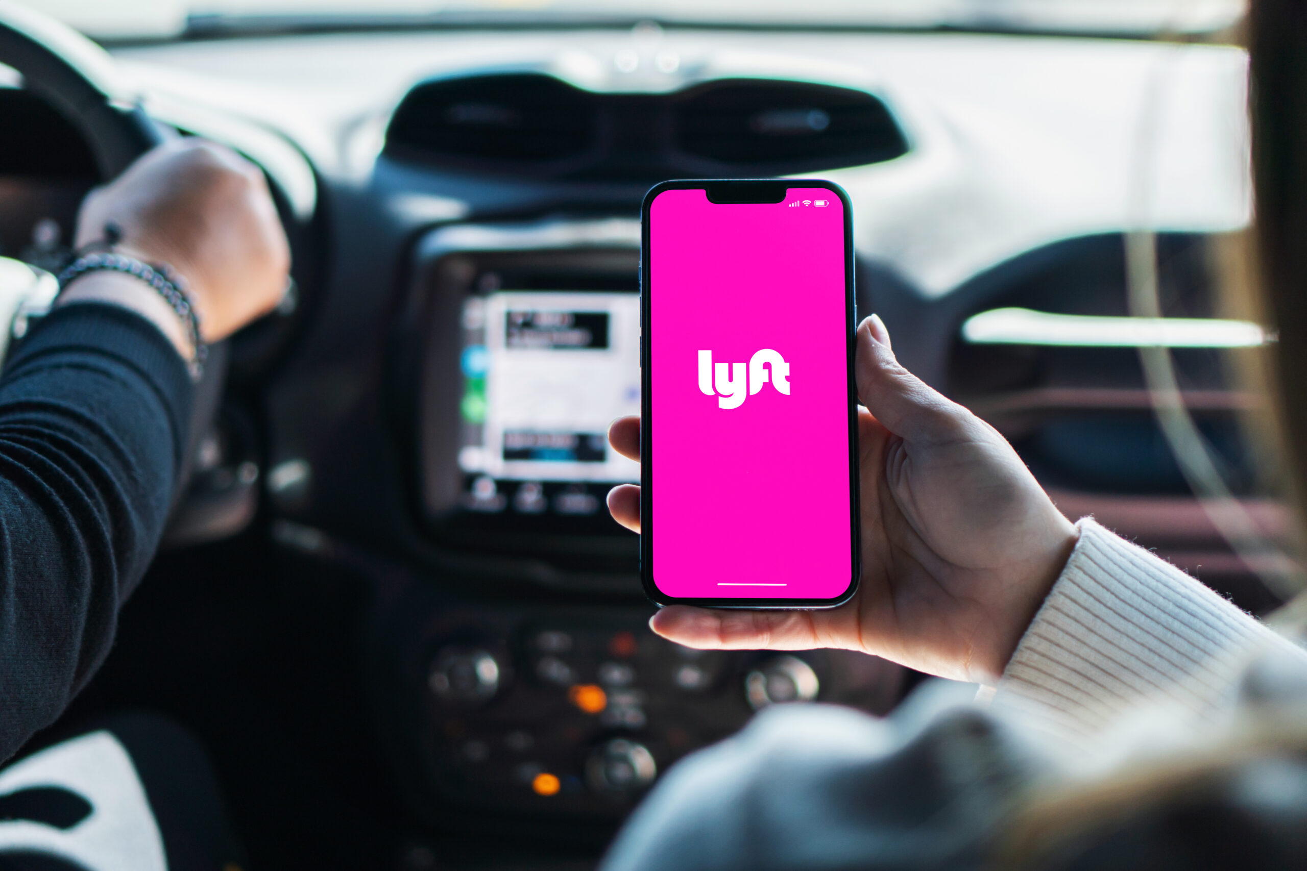 Girl inside car holding smartphone with Lyft app on screen. Rio de Janeiro, RJ, Brazil. August 2022.