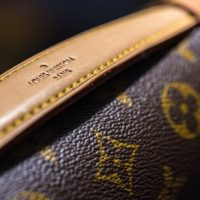 A fragment of the design of the leather handle of a Louis Vuitton women's bag, close-up. Omsk, Russia - November 08, 2021.